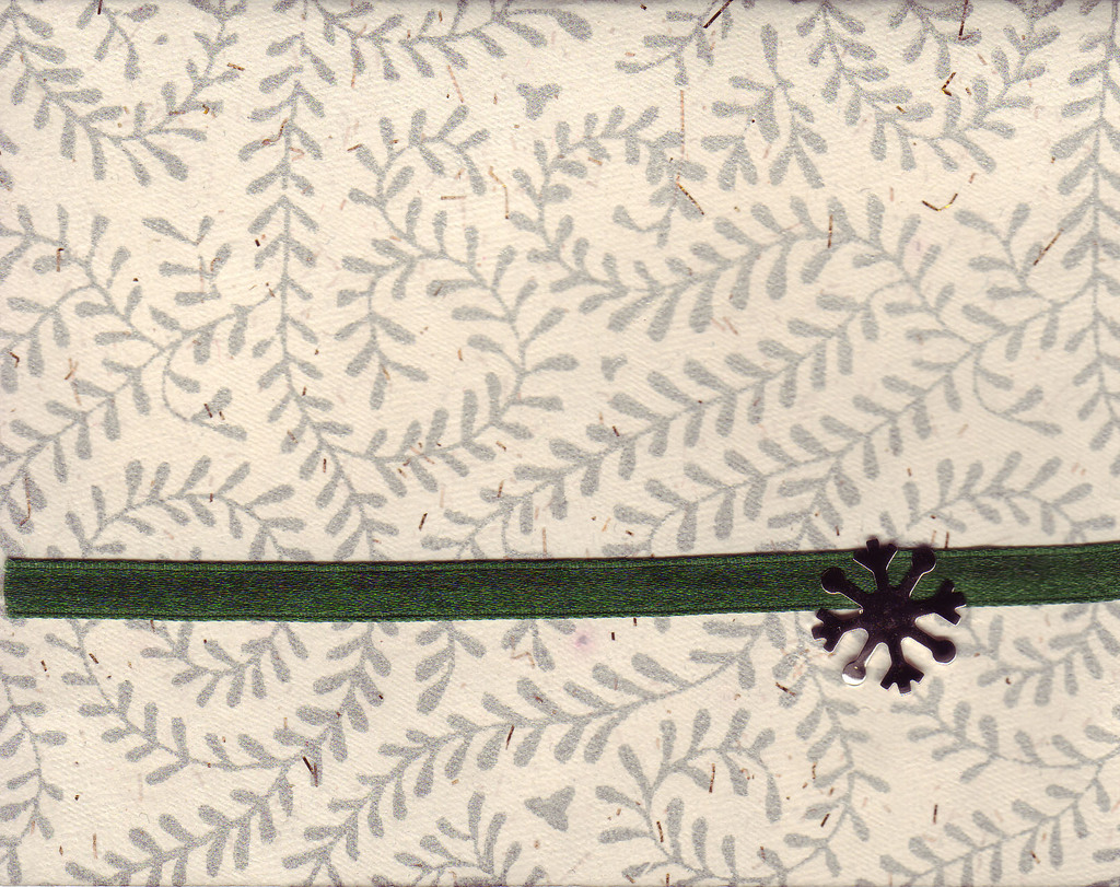 079 - Green ribbon attached to a richly textured card with fern print by a snowflake