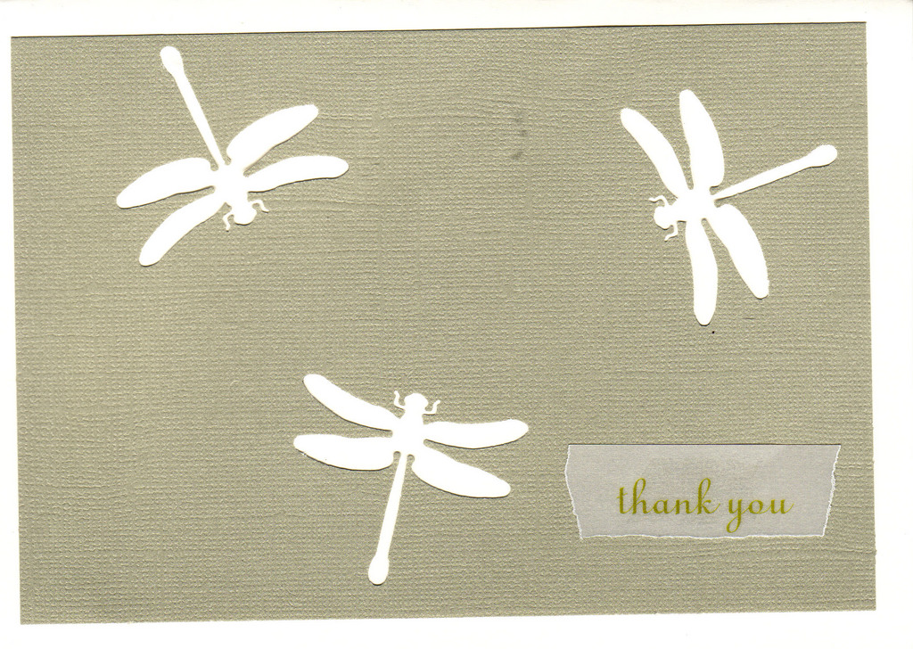 148 - 'Thank you' atop natural colored paper with dragonfly cutouts on a white card